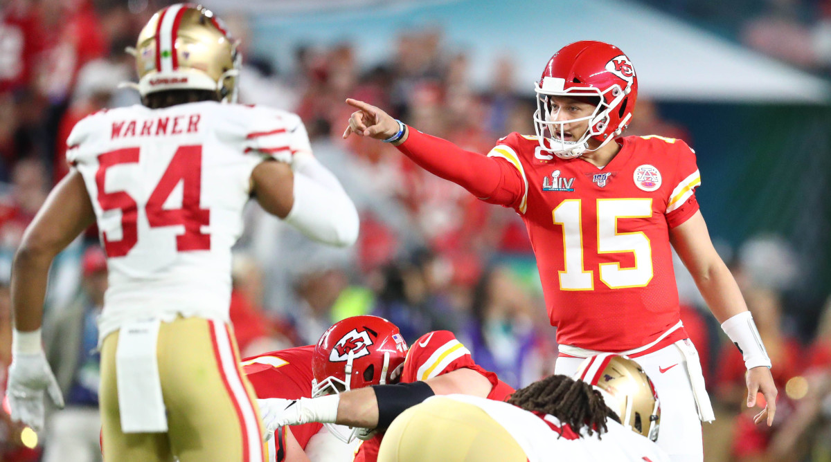Patrick Mahomes prepares for a snap, pointing and gesturing at someone as Fred Warner stands up in front of him